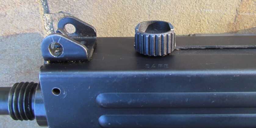 The charging handle reciprocates with the bolt and can be turned 90 degrees to lock the action.