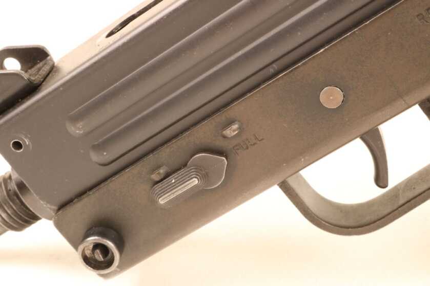 The fire selector is a rotating lever at the left front of the gun.