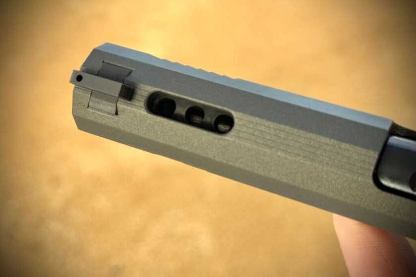 Three ports drilled into the barrel and a slide cut to allow gases to vent upwards