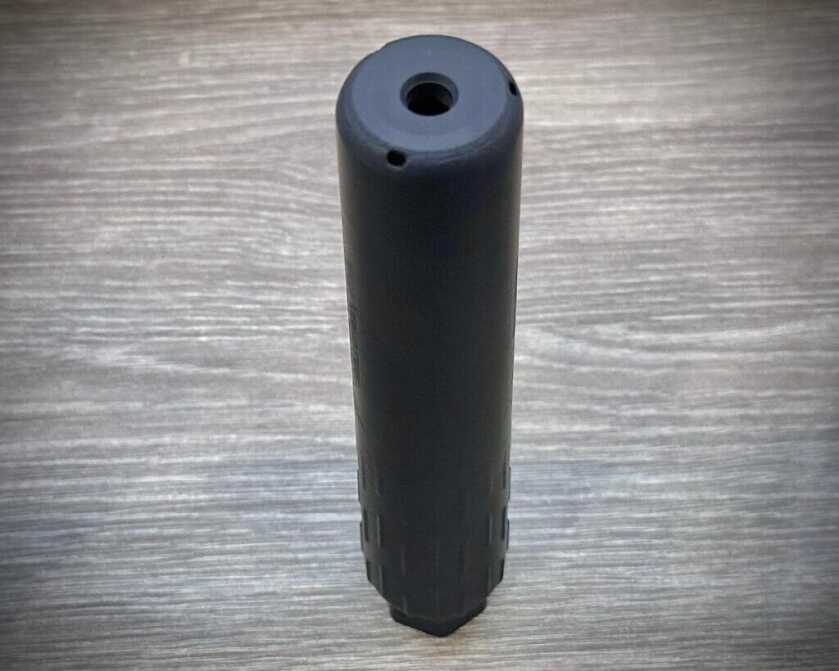 a suppressor sits on a table. 