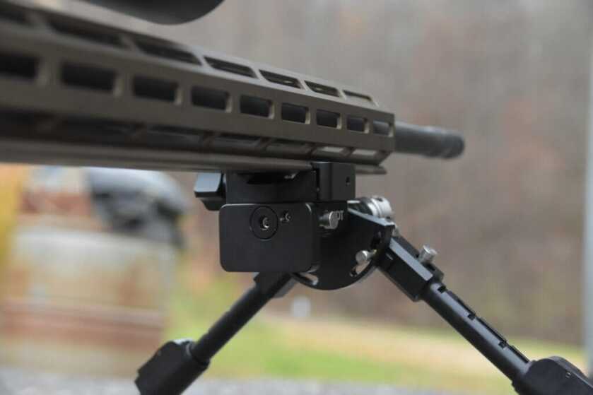A closeup of the mounting interface between rifle and a bipod.