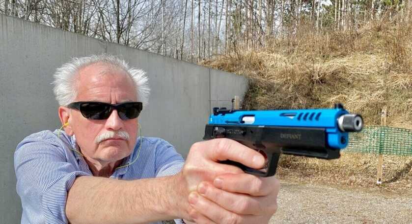 Shooter holding the blue Force 22 TB rimfire pistol outiside