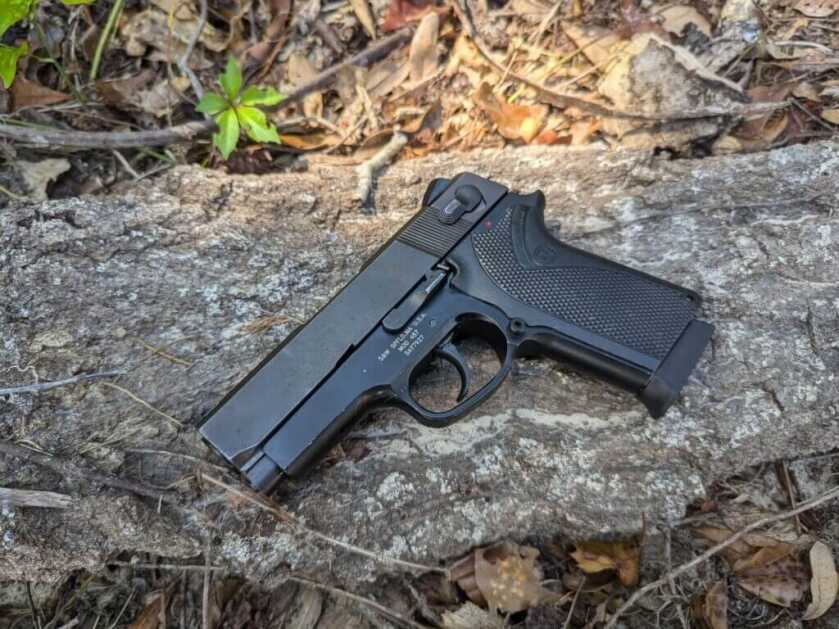 S&W 457 handgun on large piece of bark