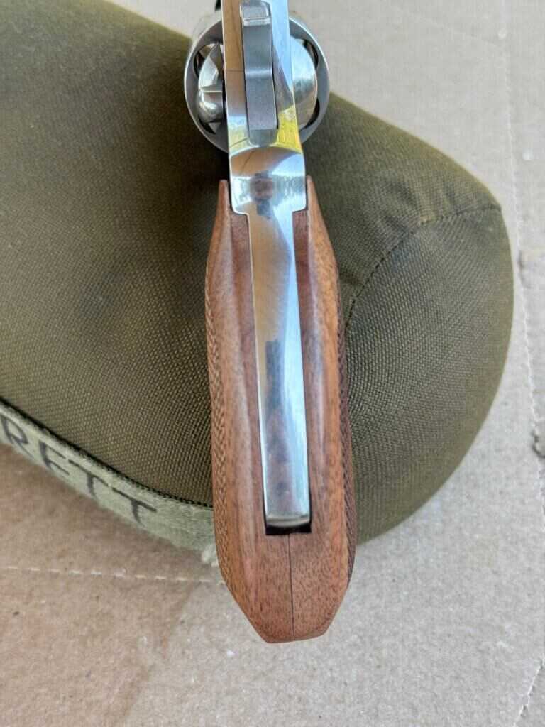 Full wooden grip of revolver on top of green game bag