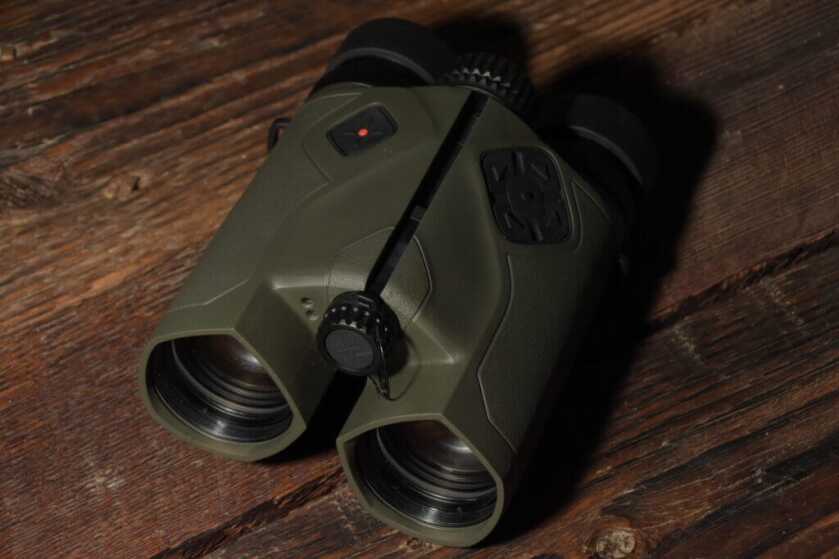 Vector X rangefinding binoculars staged on wooden background.
