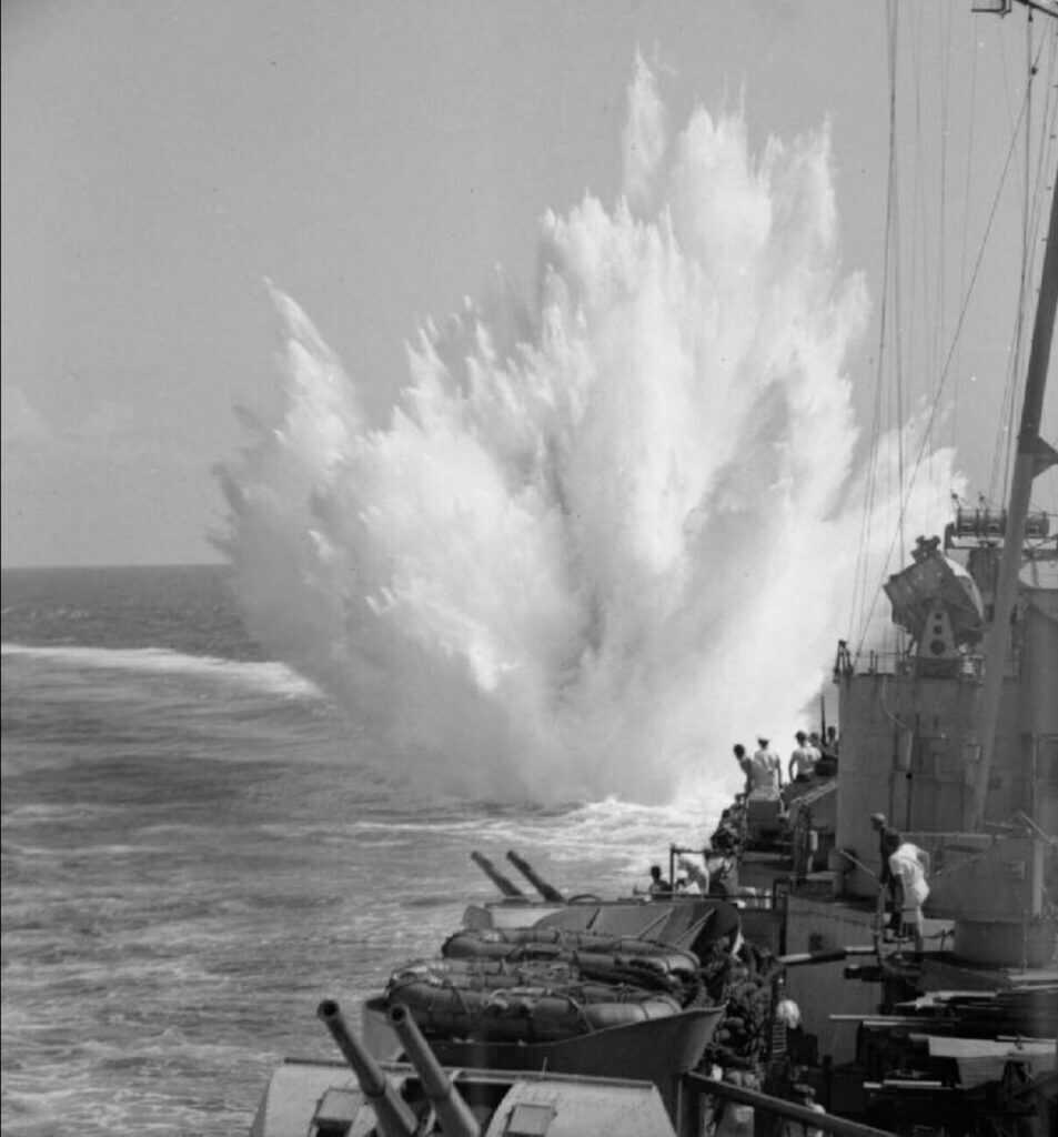 Black and white image of depth charges near a war ship