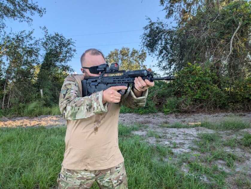 man in camo shooting rifle