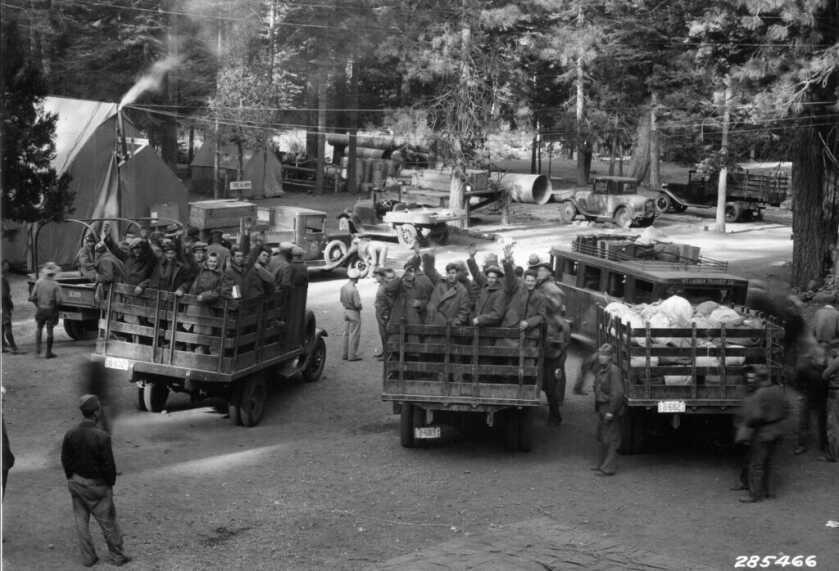 black and white photo of CCC trucks with men in the back ready to go work
