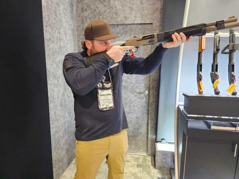 A man holds the Mossberg 940 Pro Tactical SPX like he is shooting it.